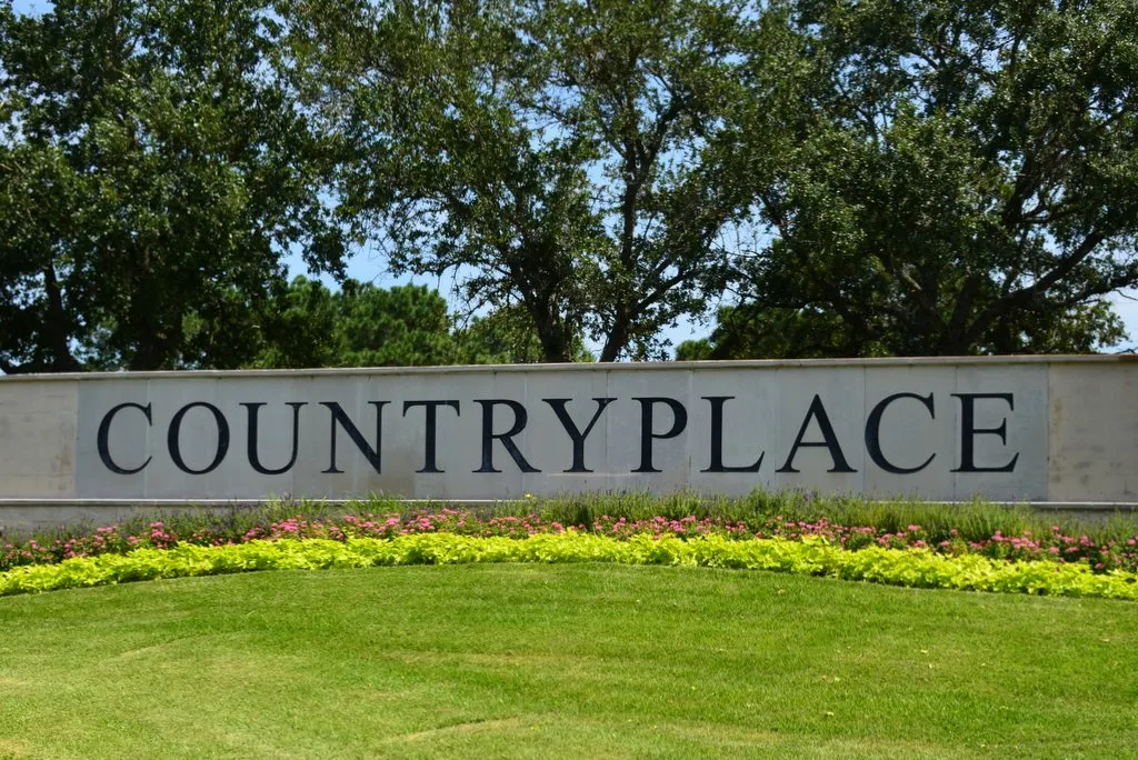 CountryPlace stone monument entrance sign framed by oak trees