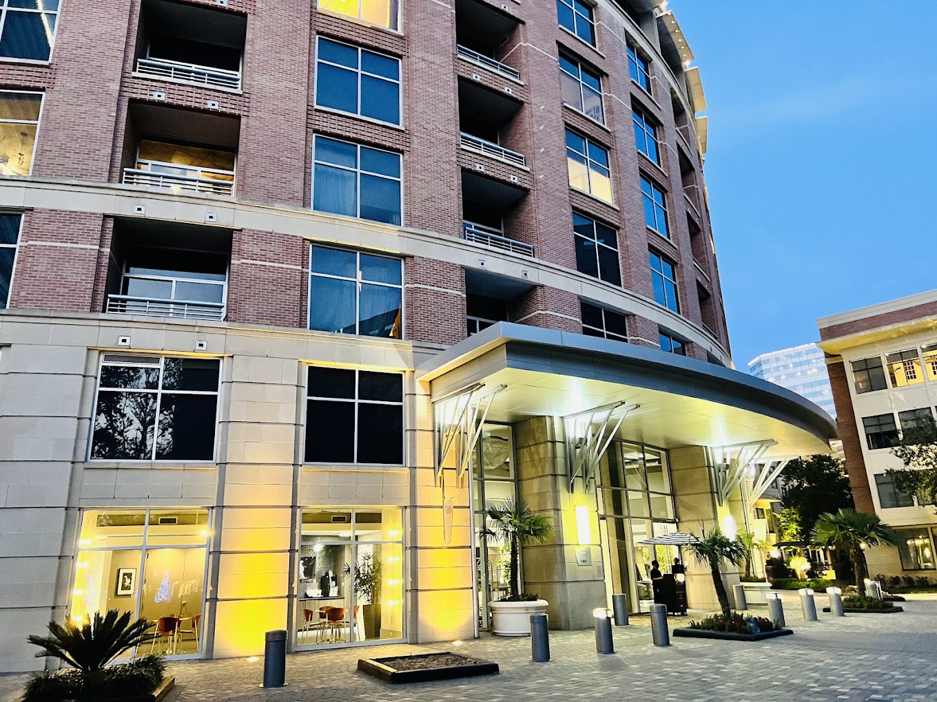 Illuminated porte-cochère entrance of The Lofts on Post Oak in Houston at dusk
