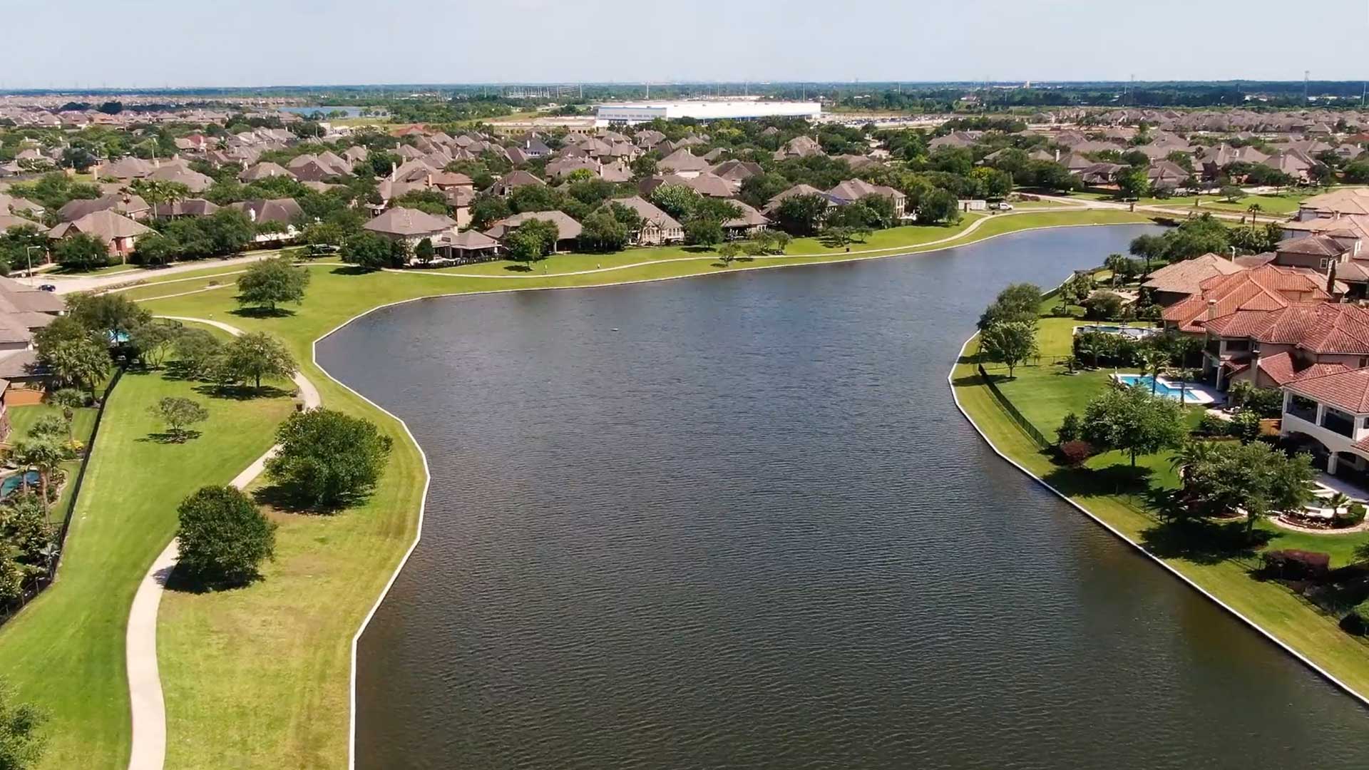 Aerial view of a scenic lake and homes at Tuscan Lakes in League City, Texas