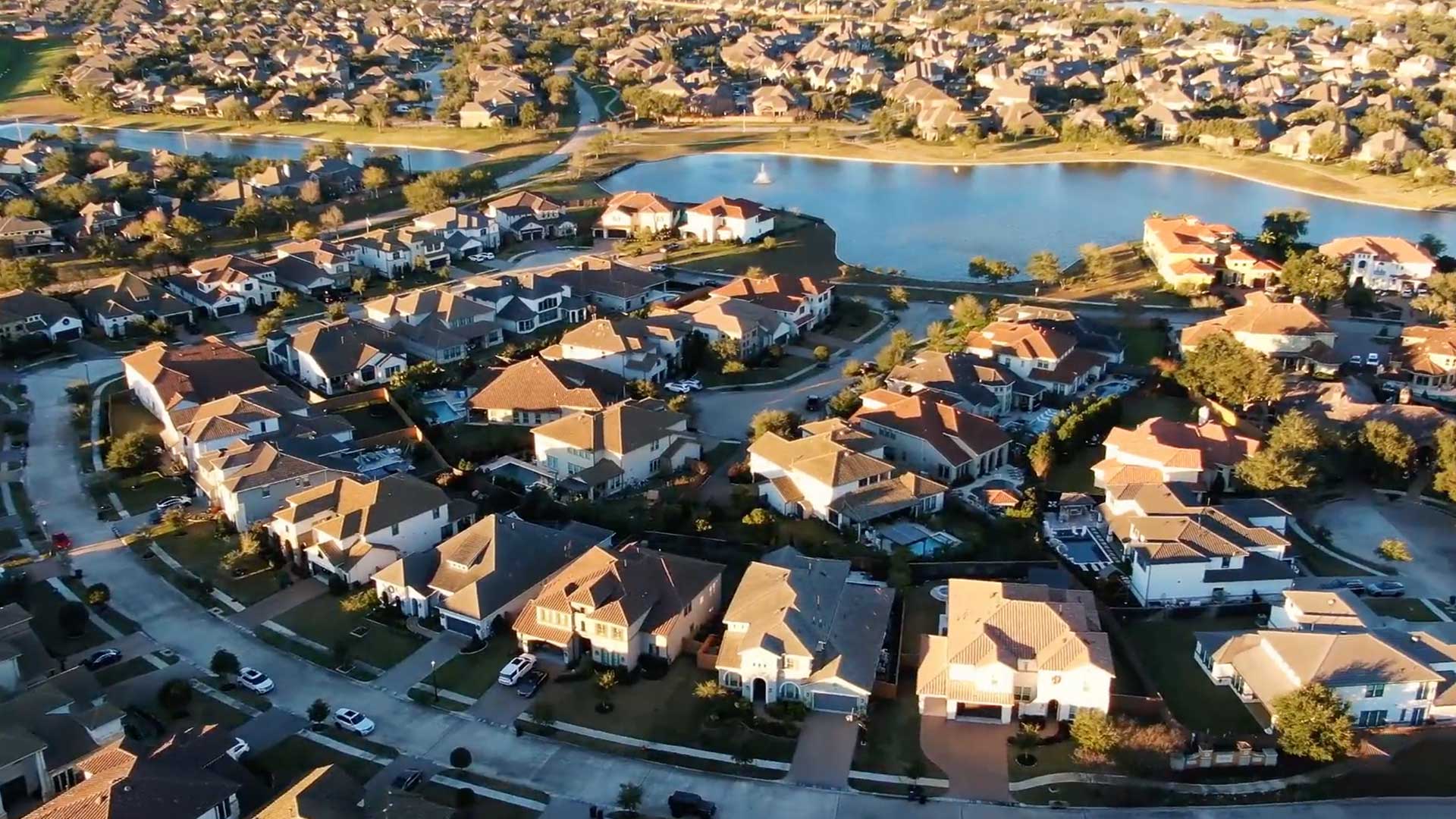 Aerial view of Mediterranean-style homes and lake at Tuscan Lakes