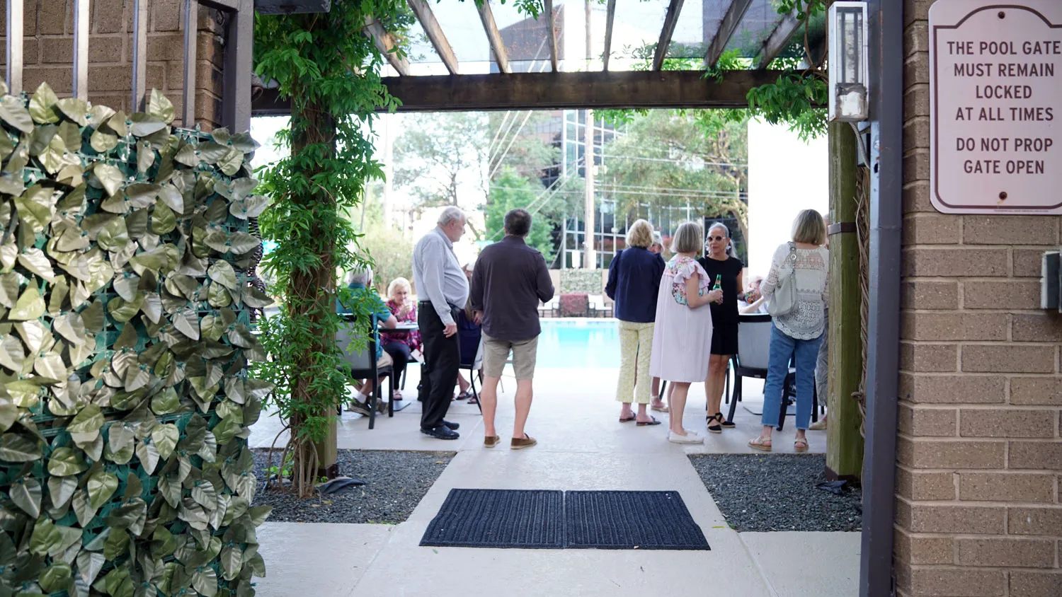 Residents gathered at a poolside courtyard event at The Woodway Condominium in Houston